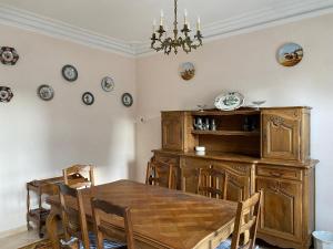 een eetkamer met een houten tafel en stoelen bij Le rêve de Jocelyne - Grande maison au Neubourg in Le Neubourg