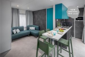 een keuken en woonkamer met een tafel en een bank bij Boutique Camping Materada Beach in Poreč