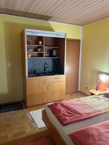 een slaapkamer met een bed en een groot entertainmentcentrum bij Apartement 2 Zur alten Press in Jennersdorf