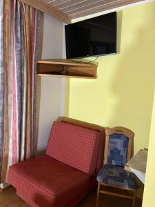 een woonkamer met een bank en een tv bij Apartement 2 Zur alten Press in Jennersdorf