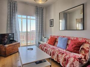 a living room with a red couch and a tv at Apartment Wunderschöner Paço D'Arcos by Interhome in Paço de Arcos