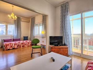 a living room with a couch and a tv at Apartment Wunderschöner Paço D'Arcos by Interhome in Paço de Arcos +20 photos