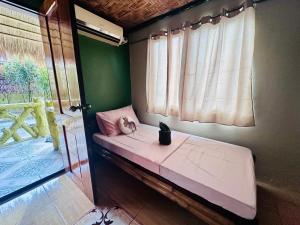 ein kleines Bett in einem Zimmer mit Fenster in der Unterkunft The Green House Port Barton in San Vicente