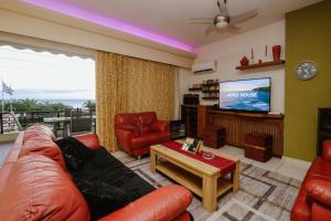 ein Wohnzimmer mit Sofa und Fernseher in der Unterkunft Sunny home crete in Ierápetra