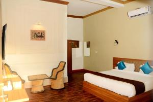 a bedroom with a bed and a table and a chair at The Vanashva in Tehla +66 photos