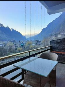 uma mesa e cadeiras em uma varanda com vista em The Kalath House em Bashist