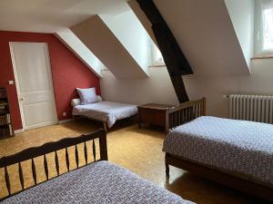 een zolderkamer met 2 bedden en een stoel bij Le rêve de Jocelyne - Grande maison au Neubourg in Le Neubourg