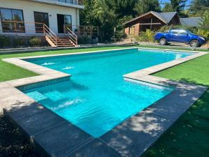 a swimming pool with blue water in a yard at Home Quillon in Quillón