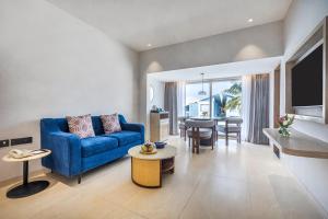 een woonkamer met een blauwe bank en een tafel bij Sterling Arka Suites, Puri in Puri