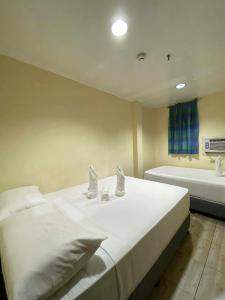 una camera con un grande letto bianco e una vasca da bagno di Zia Suites a Bugo Altre 8 foto