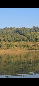 a body of water with trees in the background at Glamping Begnas in Deorāli