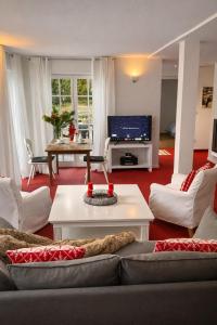 een woonkamer met een bank en een tv bij Landhaus am Plattenbichl - Luxus Apartment mit Pool und Sauna - im Sommer Bergbahn inklusive in Oberstdorf