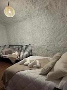 a bedroom with two beds and a wall at Bike Cueva - Los Coloraos in Gorafe