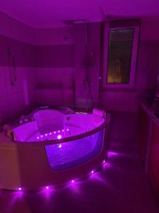 ein lila Badezimmer mit einer Badewanne mit violetten Lichtern in der Unterkunft Sunny home crete in Ierápetra