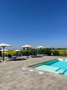 een zwembad met ligstoelen en parasols bij Il Poggio Agrisport in Poirino +46 foto's