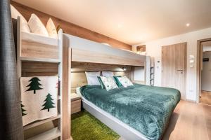een slaapkamer met een stapelbed en een groene sprei bij Emerald Stay Apartments Morzine - by EMERALD STAY in Morzine