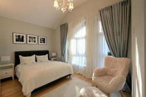 a bedroom with a bed and a chair and a window at The Rock in Sinaia