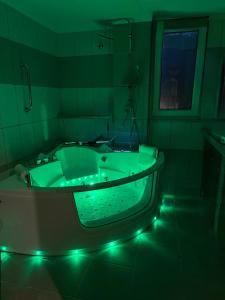 ein grünes Badezimmer mit einer Badewanne mit grünem Licht in der Unterkunft Sunny home crete in Ierápetra + 15 Fotos