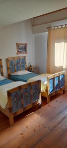 2 aparte bedden in een kamer met houten vloeren bij Agriturismo Fattoria Meneguto Societa Agricola Semplice in Cortina dʼAmpezzo