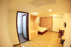 una camera d'albergo con porta che conduce a una camera da letto di City Garden Hotel a Tawau