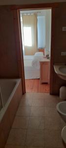 een badkamer met een bad en een slaapkamer met een bed bij Agriturismo Fattoria Meneguto Societa Agricola Semplice in Cortina dʼAmpezzo +25 foto's