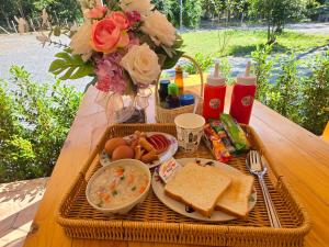 un tavolo da picnic con un cesto di cibo e pane di ไวท์ เฮ้าท์ แคมป์ ชะอม a Ban Bung Mai