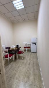 een kamer met een tafel en stoelen en een keuken bij Ugolok Xostel in Yakkasaray