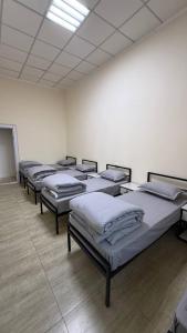 een rij matrassen in een kamer bij Ugolok Xostel in Yakkasaray
