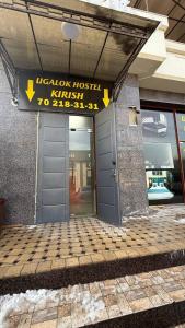 een gebouw met een deur en een bord erop bij Ugolok Xostel in Yakkasaray