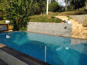 een zwembad in een achtertuin met een trap bij Sítio Refúgio Primavera in Monte Verde +26 foto's