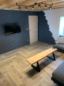 a living room with a table and a brick wall at L'Ail des Ours in Les Estables