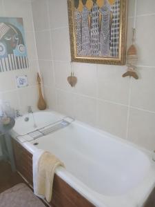 een badkamer met een ligbad en een wastafel bij Jann's Cozy Cottage in Bredasdorp