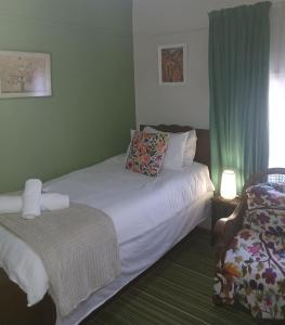 een hotelkamer met twee bedden en een stoel bij Jann's Cozy Cottage in Bredasdorp