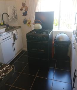 een keuken met een fornuis met een pot erop bij Jann's Cozy Cottage in Bredasdorp +26 foto's