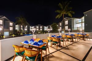 een rij tafels en stoelen op een patio 's nachts bij Sterling Arka Suites, Puri in Puri