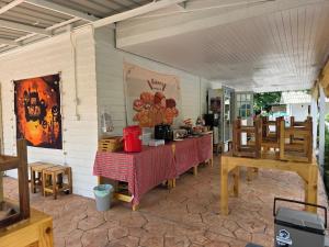 a restaurant with two tables and chairs and a table with red table cloth at ไวท์ เฮ้าท์ แคมป์ ชะอม in Ban Bung Mai