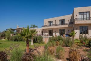 索维拉Lalla Essaouira, Villa Najma avec piscine pour 15 personnes的一座前面有棕榈树的建筑