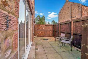 a patio with a wooden fence and a bench at Yeavering - North East Escapes in Wooler