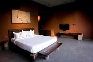 a bedroom with a large white bed and a television at Ayana Villa By KPM in Varagampadi