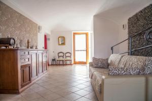 een woonkamer met een bank en een keuken bij Il Poggio Agrisport in Poirino