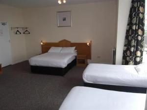 een hotelkamer met twee bedden in een kamer bij Esplanade Hotel - Clacton On Sea, Beachfront Hotel by OYO in Clacton-on-Sea