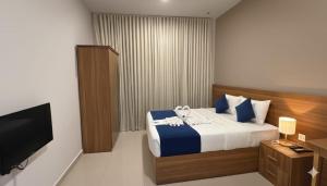 een slaapkamer met een bed en een flatscreen-tv bij Al Khaleej Plaza Furnished Hotel Apartments in Ajman  +20 foto's