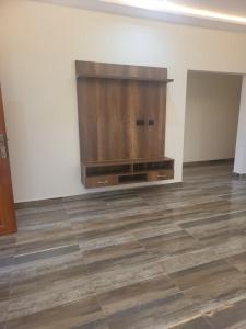a living room with a large wooden entertainment center at Property for rent in Accra +12 photos