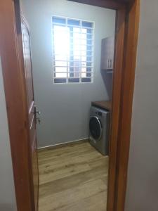 a door to a room with a washing machine and a window at Property for rent in Accra
