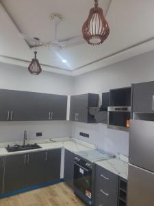 a kitchen with black and white counters and appliances at Property for rent in Accra