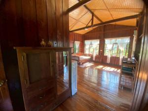 een lege kamer met houten vloeren en ramen in een huis bij Elephant House and Pool Villas 