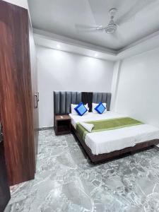 a bedroom with a bed with blue pillows on it at Hotel the haveliya-1 mint from new delhi railway station & connaught place in New Delhi