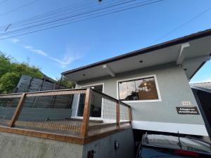 een huis met een groot terras en een auto ervoor geparkeerd bij Casa Brisa do Siriú in Garopaba