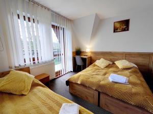 a bedroom with two beds in a room with windows at Ośrodek Wypoczynkowy Baca in Poronin +51 photos