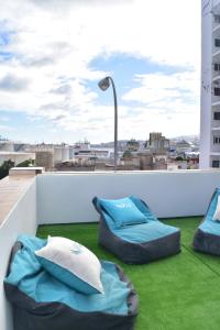 a balcony with two bean bags on the grass at La Isleta Nest Hostel in Las Palmas de Gran Canaria